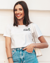 Load image into Gallery viewer, Female model wearing a white powered by plants shirt
